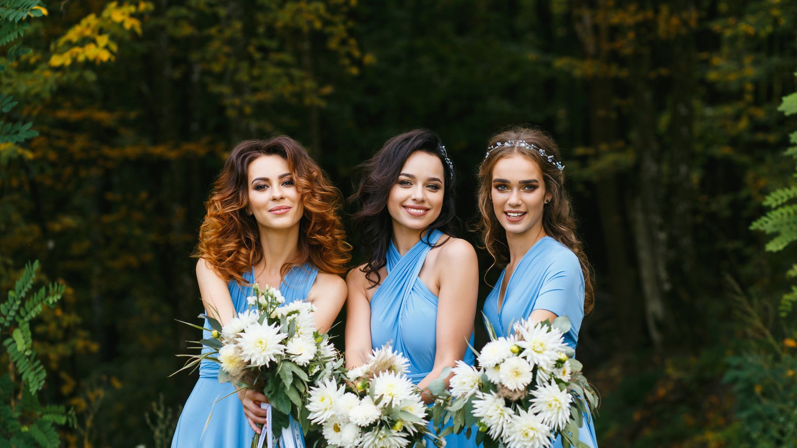 Three pretty bridesmaids holding flowers