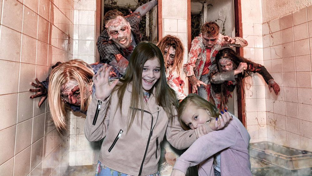 Girls posing in glam booth with zombie attack backdrop