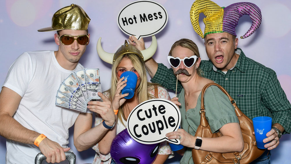 Adults having fun in the photo booth with props